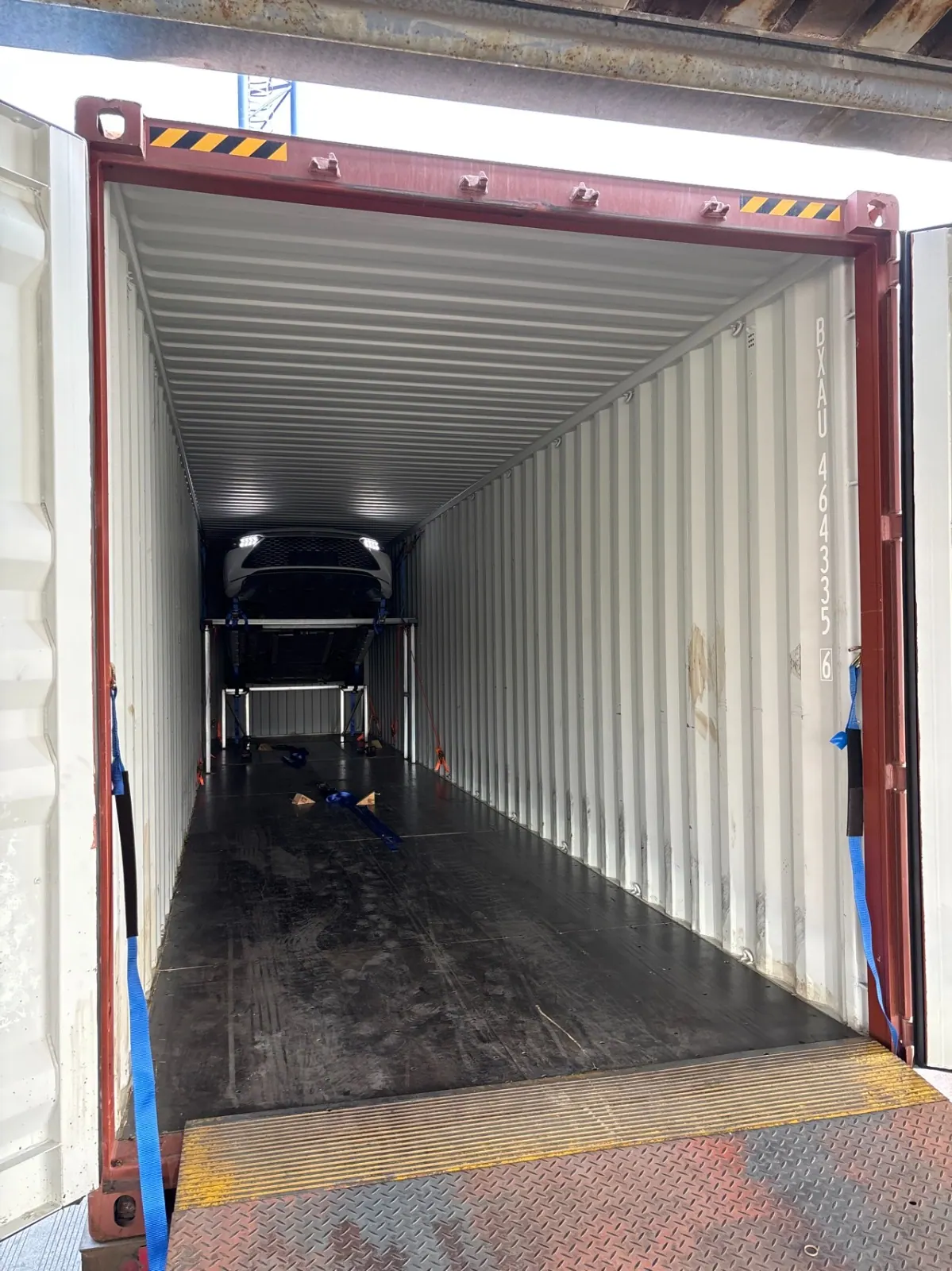 Vehicle strapped and secured on the upper rack of a Sino Gear export container